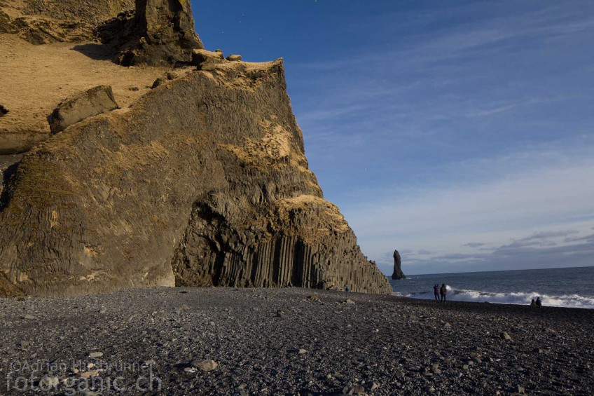 Der riesige Basaltsäulenfelsen von Vík í Mýrdal mit einer Felsnadel des Reynisdrangar im Hintergrund.