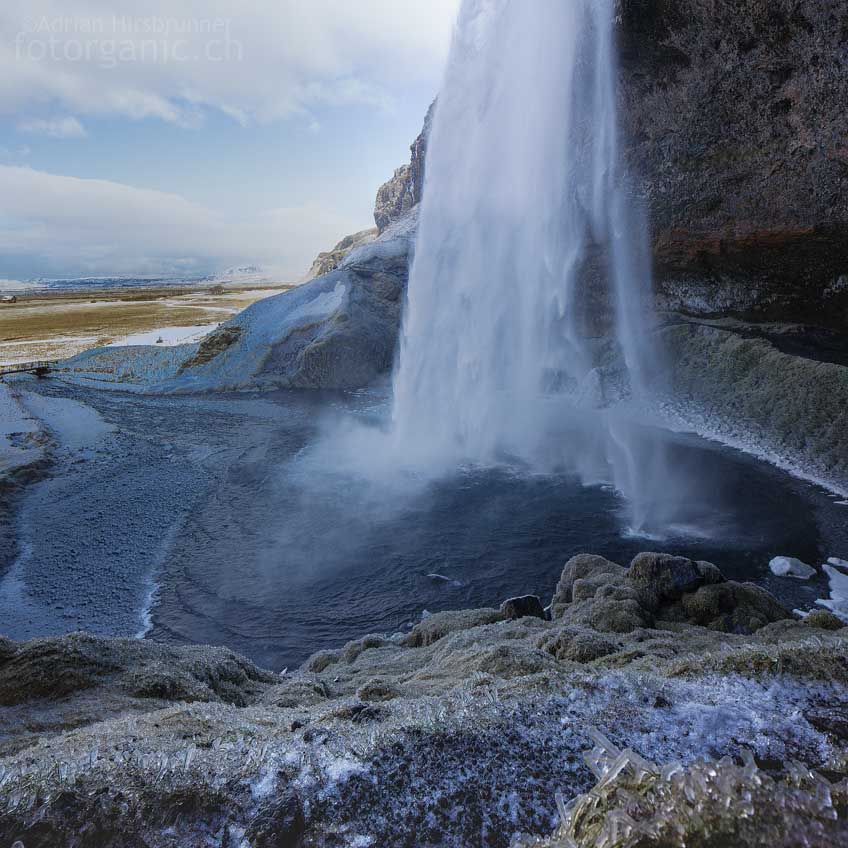 Alles um den Wasserfall Seljalandsfoss ist im Winter mit einer Eispatina überzogen.